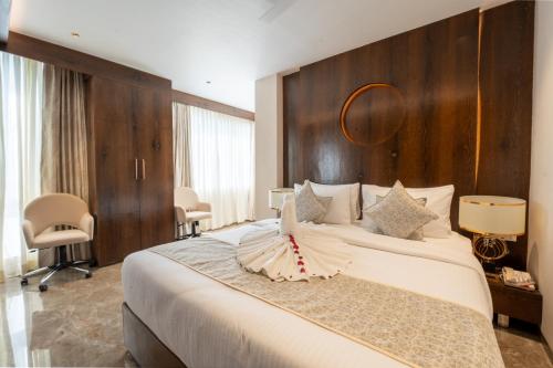 a bedroom with a large bed with a wooden headboard at Ramee Tarang Hotel Indore in Indore