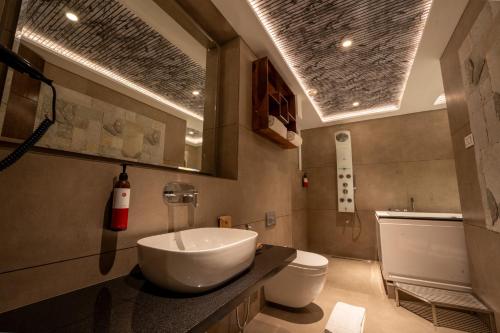 a bathroom with a sink and a toilet at Ramee Tarang Hotel Indore in Indore