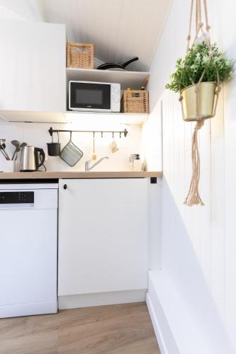 a white kitchen with white cabinets and a sink at Au Petit Sommet - Cerf Brun Appartement centre ville 35M2 in Modane