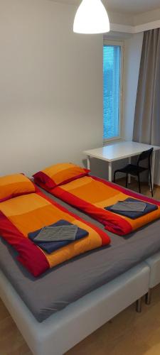 a bed in a room with a table and a bedspread at Apartment Kauppatie, neljälle hengelle in Laihia