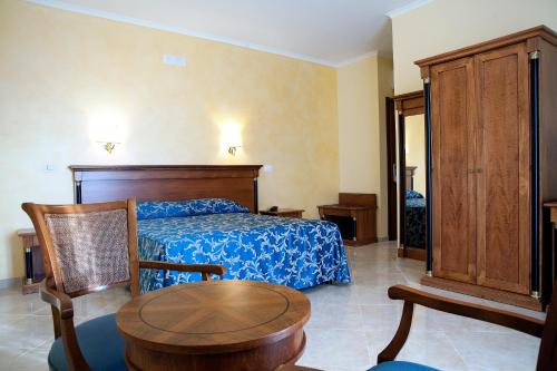 a bedroom with a bed and a table and chair at Hotel Aquila in Aprilia