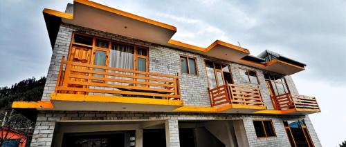a house with a balcony on the side of it at Dreamscape Manali in Manāli