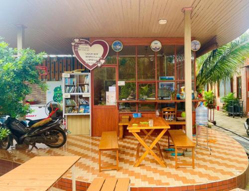 a restaurant with a table and a motorcycle in front of it at The Lana Ho Tram Homestay in Xuyên Mộc