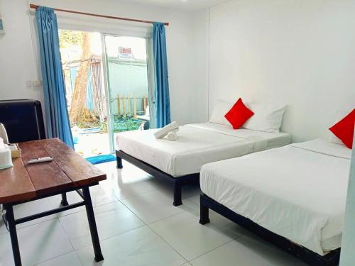 a room with two beds and a table and a window at Seasonsamed Resort in Ao Phutsa