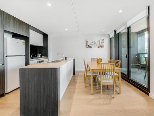 a kitchen and dining room with a table and chairs at Pars apartments - Melbourne Quarter- unique View of city and Yarra in Melbourne