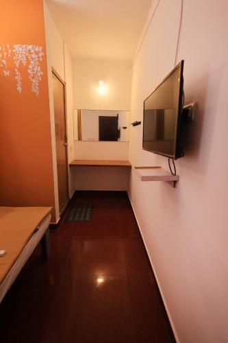 a small hallway with a television on a wall at JK Residency in Puducherry