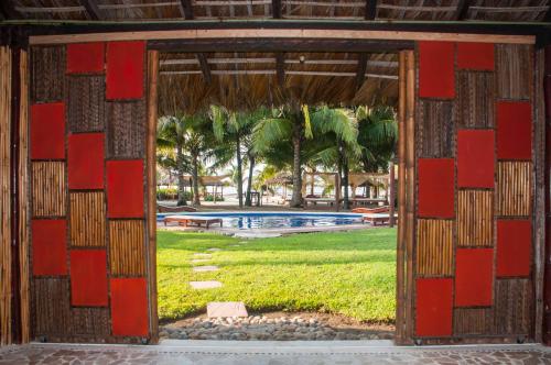 an open door into a yard with a pool at Bambuddha Centro Holistico in Barra Vieja