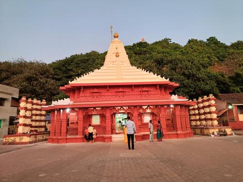 a man standing in front of a red temple at B-5 Sea Vista Apartment Dream Home in Ratnagiri