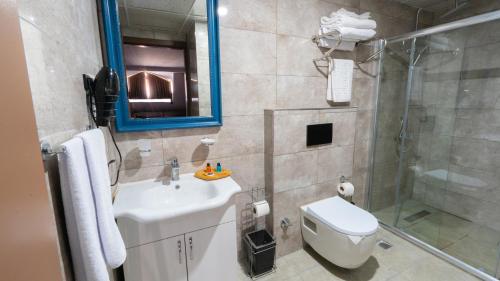 a bathroom with a toilet and a sink and a shower at Gardan Hotel in Beylikduzu