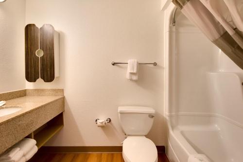 a bathroom with a toilet and a sink and a tub at Motel 6-Brownsville, TX in Brownsville