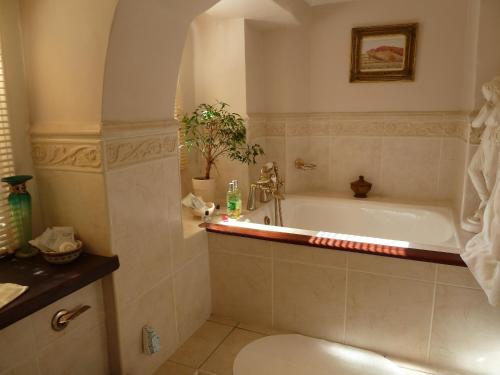 a bathroom with a tub and a toilet at Queen Anne House in Portland