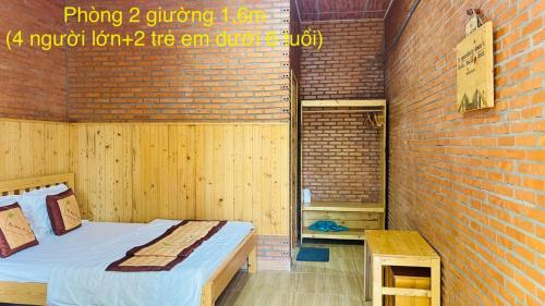 a room with a bed and a brick wall at The Lana Ho Tram Homestay in Xuyên Mộc