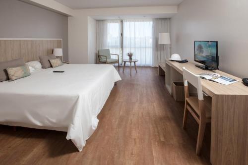 a hotel room with a large bed and a desk at Brizo Neuquén in Neuquén