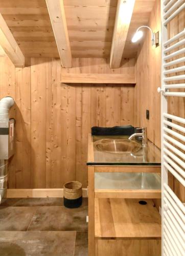 - une salle de bains avec lavabo dans une chambre en bois dans l'établissement Appartement confortable avec vue montagne à Peisey-Nancroix, à Peisey-Nancroix
