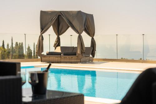 a pool with a gazebo next to a swimming pool at Zenvillas in Lefkada Town
