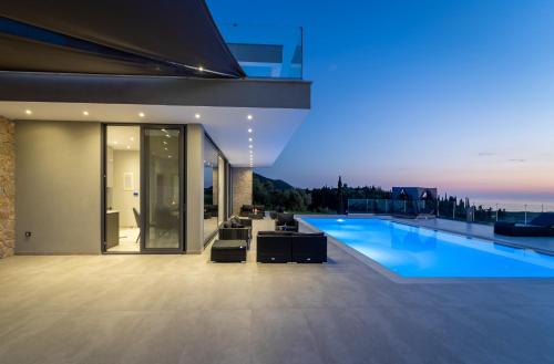 a house with a swimming pool at night at Zenvillas in Lefkada Town