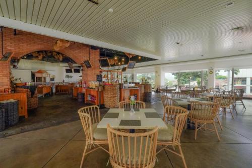 a restaurant with tables and chairs and a brick wall at Royal Padjadjaran Hotel in Bogor