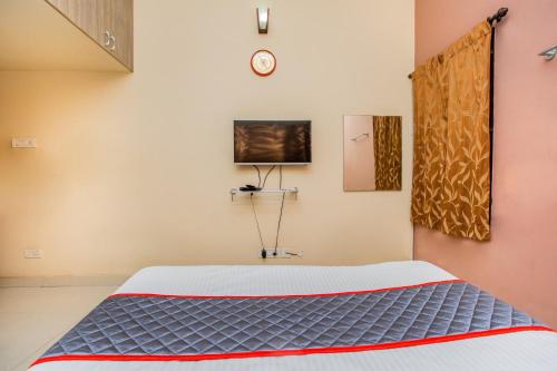 a bedroom with a bed and a tv on the wall at HEAVEN PLEASANT STAy in Chennai
