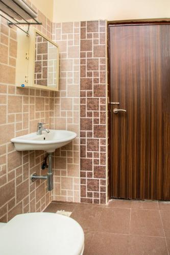 a bathroom with a sink and a toilet and a door at HEAVEN PLEASANT STAy in Chennai