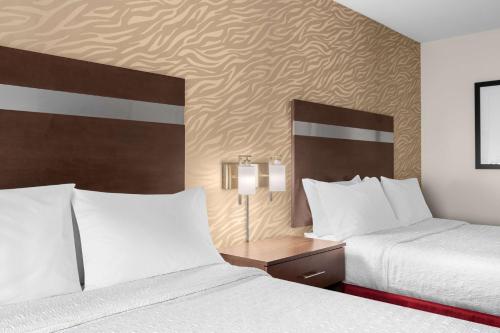 a hotel room with two beds and a table with two lamps at Hampton Inn Atlanta McDonough in McDonough