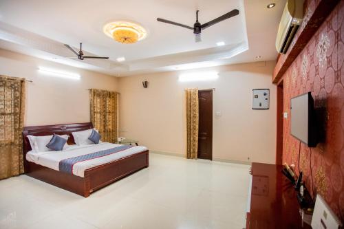 a bedroom with a bed and a flat screen tv at HEAVEN PLEASANT STAy in Chennai