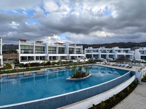 a large building with a large swimming pool at Luxurious Apartment with Private Jacuzzi in Kérynia