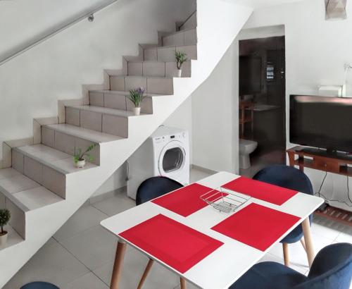 a dining room with a table and chairs and stairs at Appartement charmant au Tampon de 55 m² avec terrasse in Le Tampon