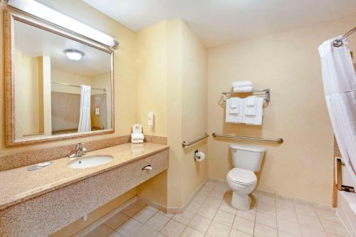 a bathroom with a toilet and a sink and a mirror at Comfort Inn & Suites Rawlins in Rawlins