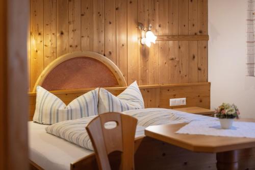 a bedroom with a bed with a wooden wall at Haus Bergzauber in Neustift im Stubaital