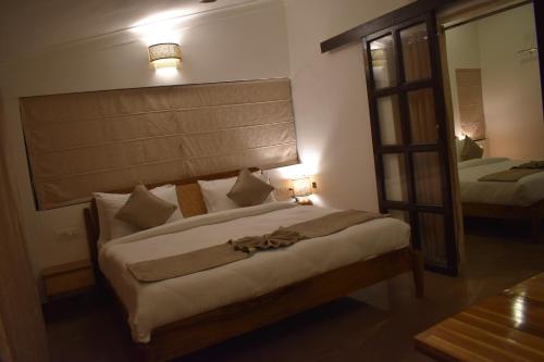 Postel nebo postele na pokoji v ubytování 3Acres Resorts Dehradun