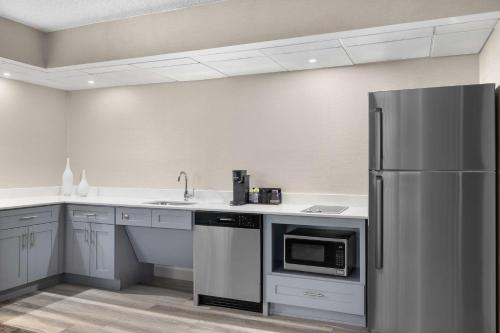 a kitchen with a refrigerator and a sink at Homewood Suites By Hilton Downers Grove Chicago, Il in Downers Grove