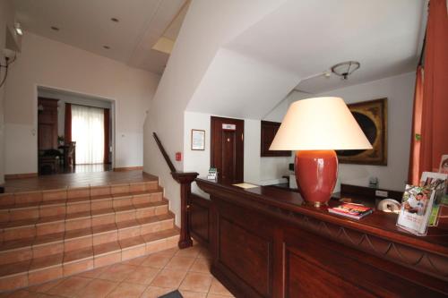 a hallway with stairs and a lamp on a table at Hotel Drei Linden in Lünen
