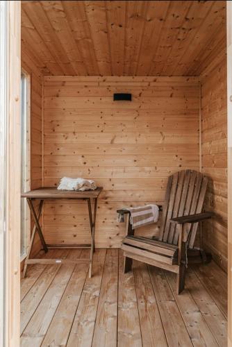 a wooden sauna with a wooden chair and a table at Sea & Sun in Wierzchucino