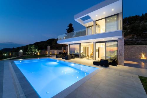 a villa with a swimming pool at night at Zenvillas in Lefkada Town