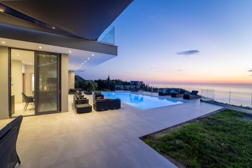 a house with a swimming pool with a view of the ocean at Zenvillas in Lefkada Town