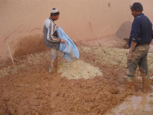 two men are standing in auddle of mud at Kasbah Ait Kassi in Boumalne