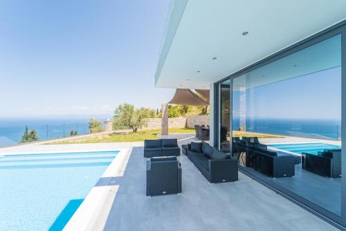 a villa with a swimming pool and a view of the ocean at Zenvillas in Lefkada Town