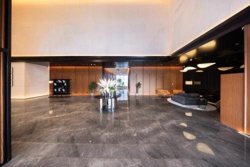 广州广州荔湾城际酒店 LntercityHotel Guangzhou Liwan的大房间,设有大堂,配有桌子和鲜花