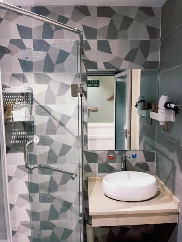 a bathroom with a sink and a glass shower at 张家界小情调精品民宿 in Zhangjiajie