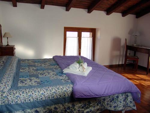 a bedroom with a bed with a purple comforter at Casa Vacanze Cascina Campagnola in Pozzolengo