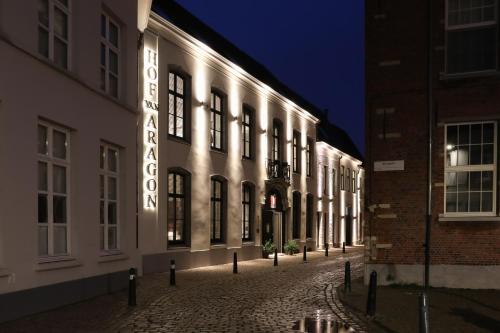 a building with a neon sign on the side of it at Hotel Hof van Aragon in Lier