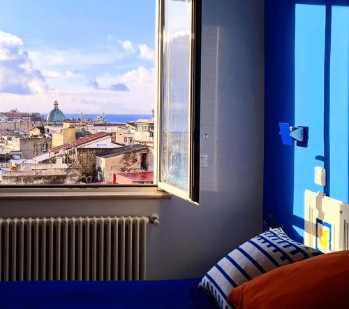 a bedroom with a view of a city from a window at Belvedere Quartieri Napoli in Naples