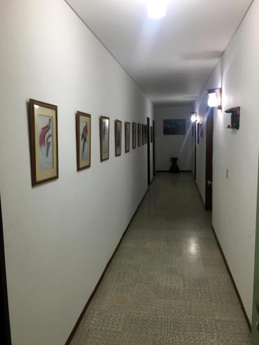 a long hallway with paintings on the walls at Finca Jerusalen in Tobia