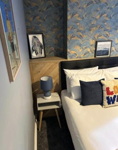 a bedroom with a bed with a blue and gold wallpaper at The Stag Hotel and Mailmans Arms in Lyndhurst