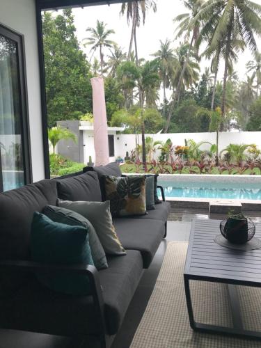 a living room with a couch and a swimming pool at Villa Beau Rivage in Bachok
