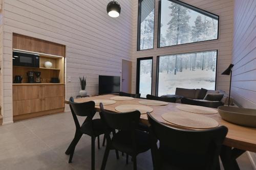 a room with a table and chairs and a couch at Holiday Villa QUU C in Ylläs