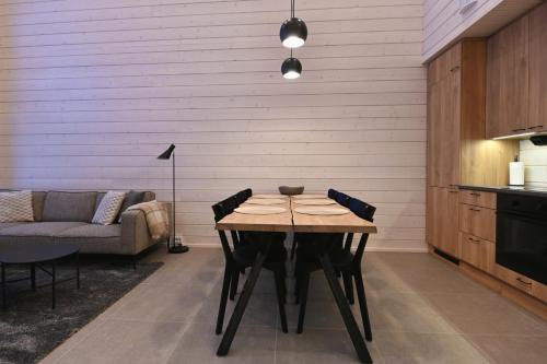 a dining room with a table and a couch at Holiday Villa QUU C in Ylläs