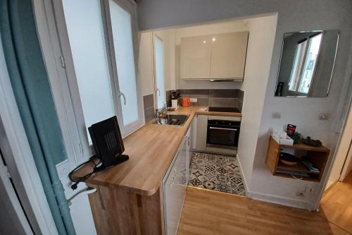 une petite cuisine avec un comptoir en bois et un évier dans l'établissement Cosy apartment with all amenities, à Paris