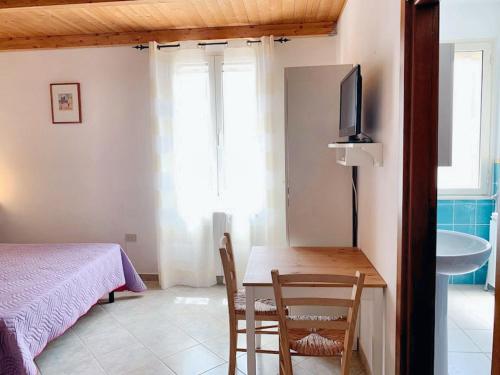 a bedroom with a table and a bed and a television at Charming Apartment in Galtellì in Galtellì