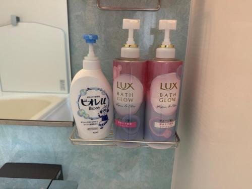 a shelf with four bottles of laundry detergents in a bathroom at Taito's villa in Isumi